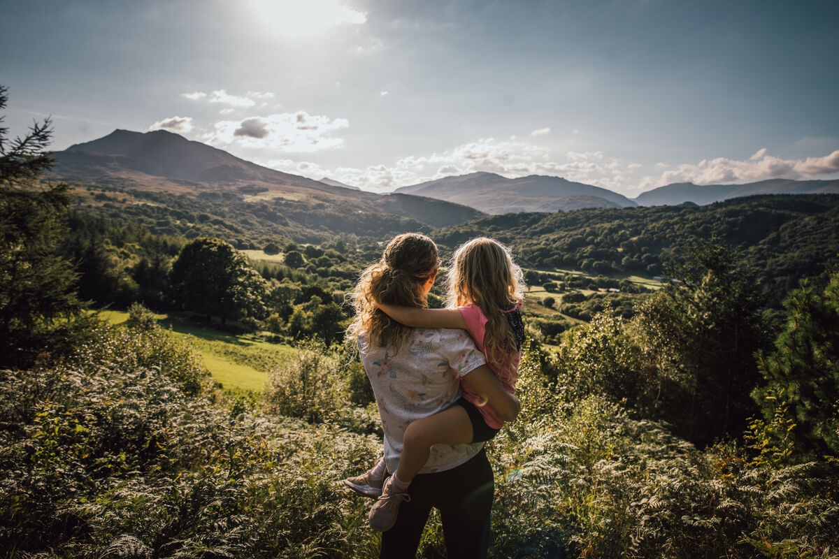 Woman and child looking at forests and mountains