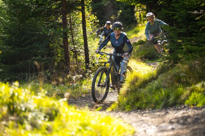 Tair menyw yn beicio ar lwybr yn BikePark Wales